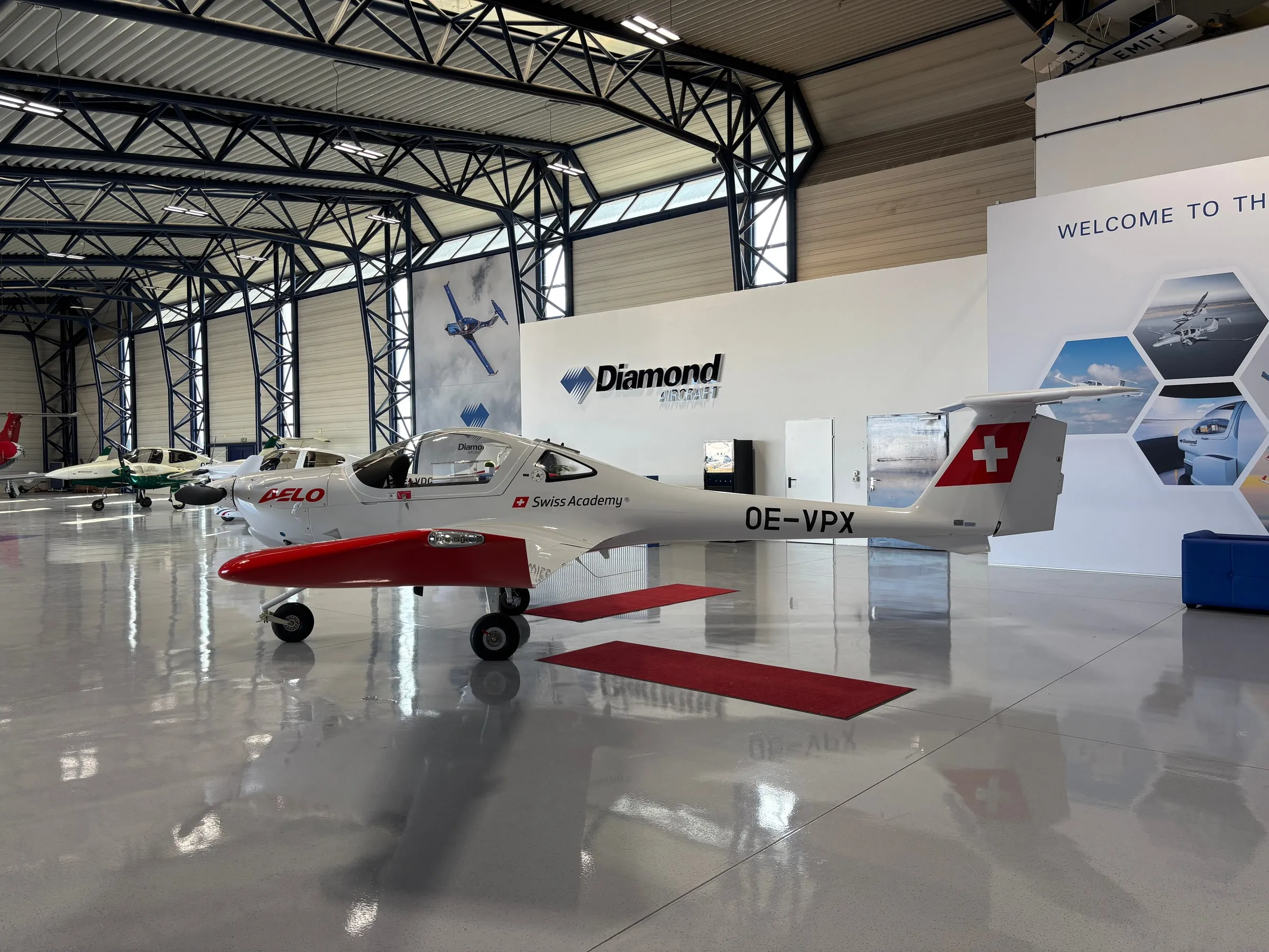 A row of Diamond aircraft on display in the bright factory hangar