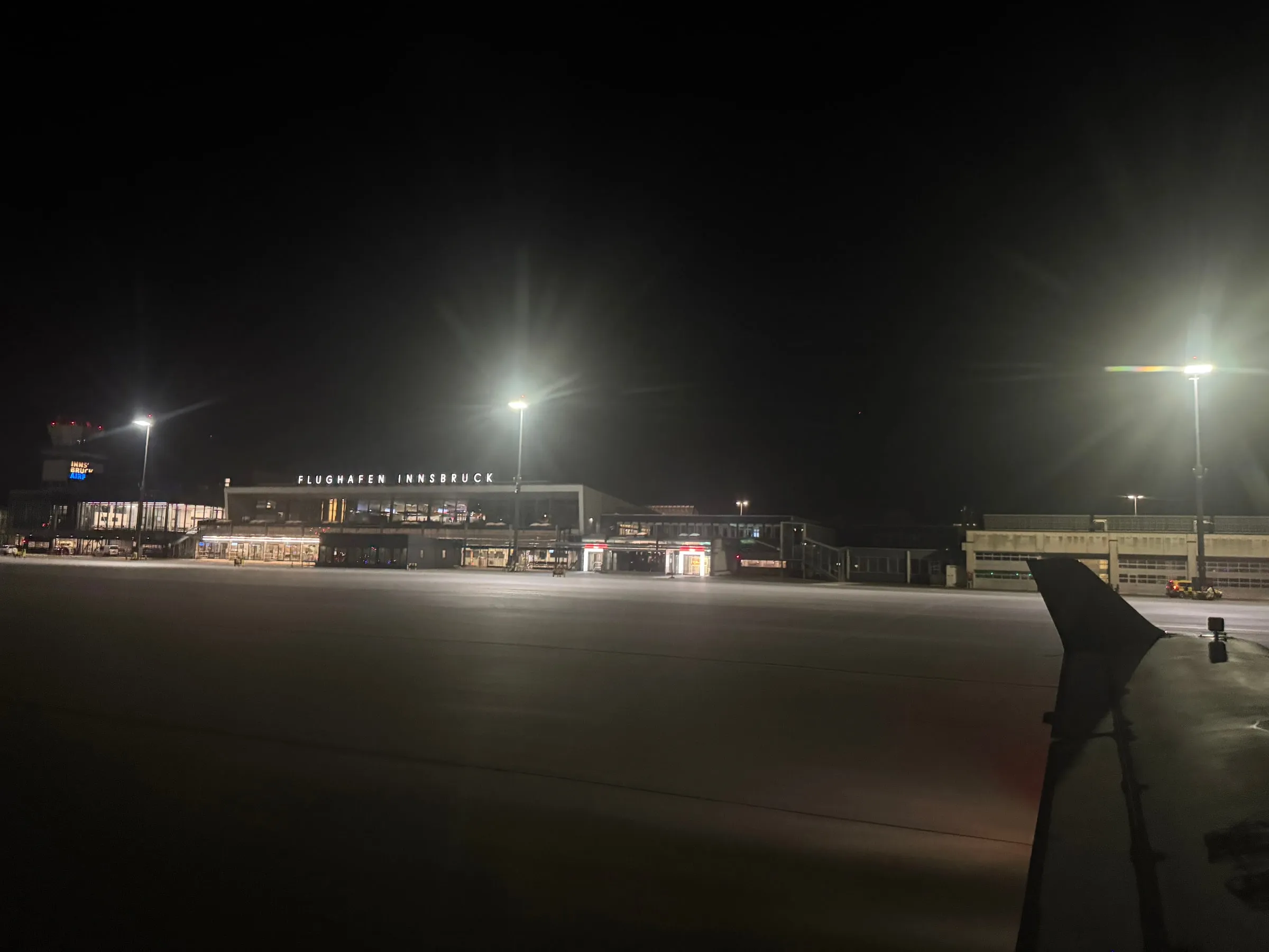 Innsbruck Airport terminal and apron illuminated at night