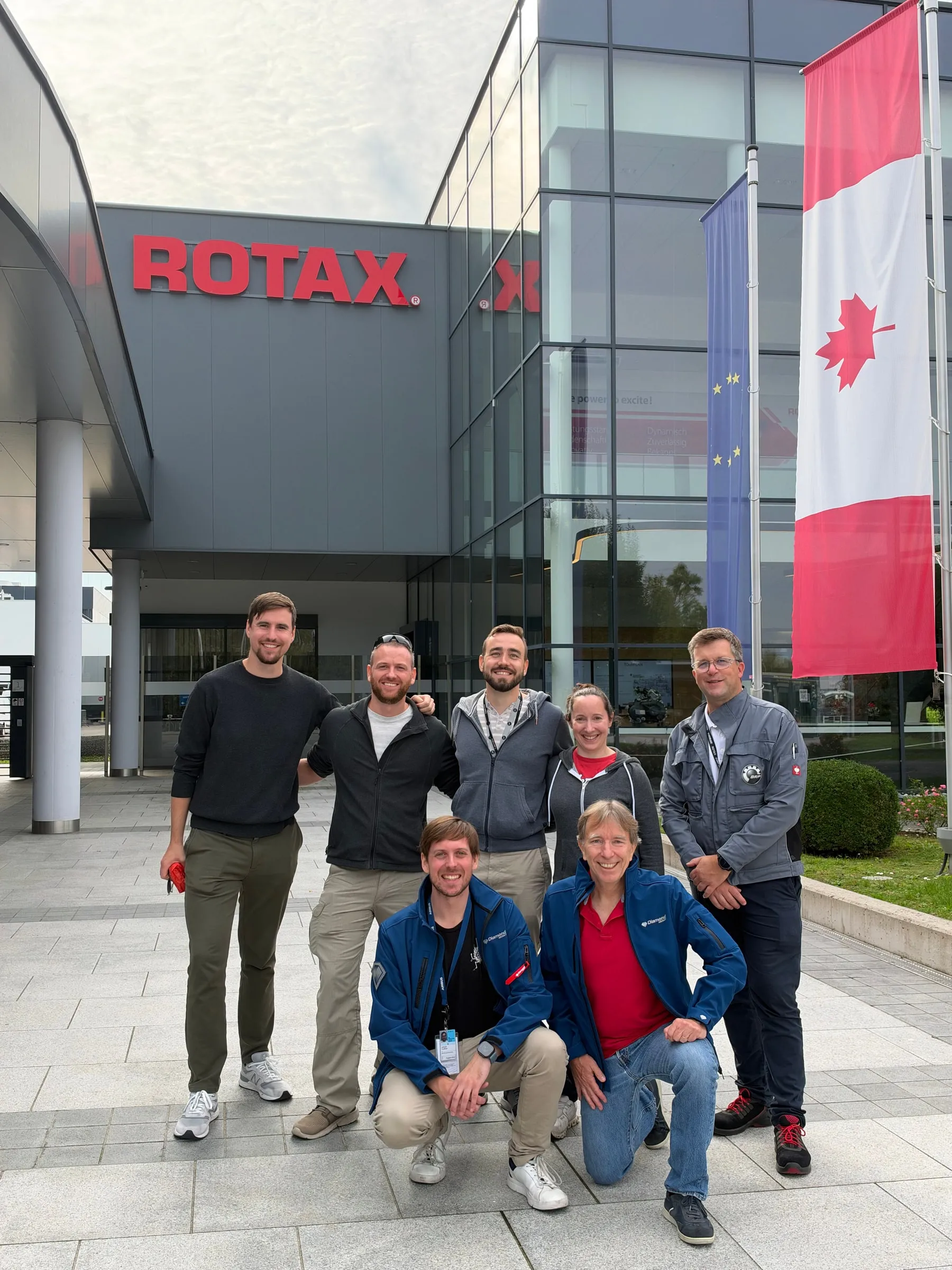 The visiting group outside the ROTAX building beside Austrian and Canadian flags